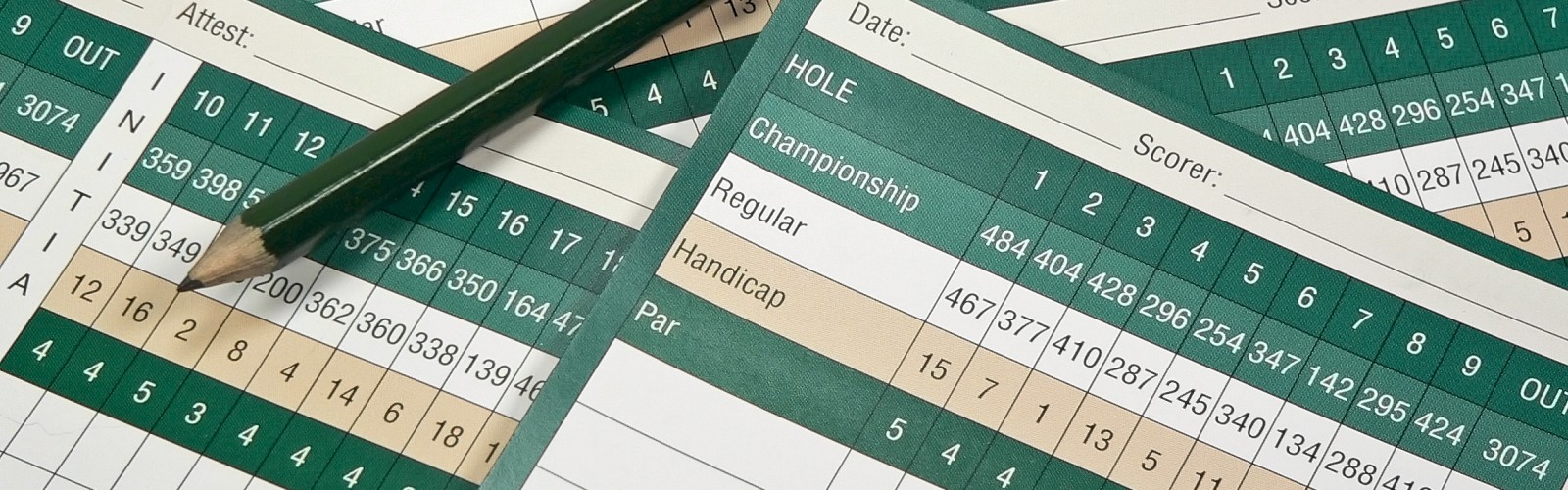 The image shows a collection of golf scorecards and a pencil arranged on them.