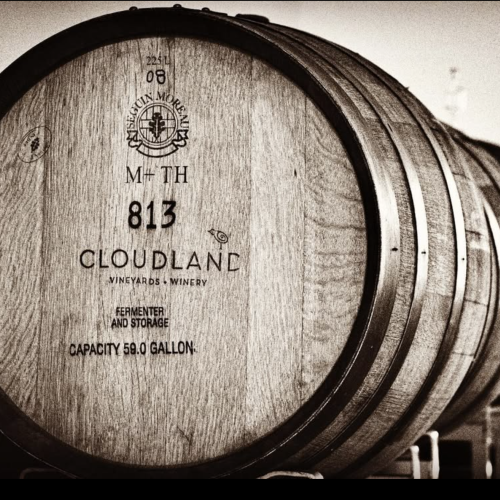 The image shows a stack of wooden barrels labeled 