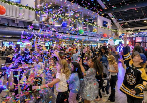 People celebrating indoors with colorful confetti and balloons, creating a festive atmosphere.