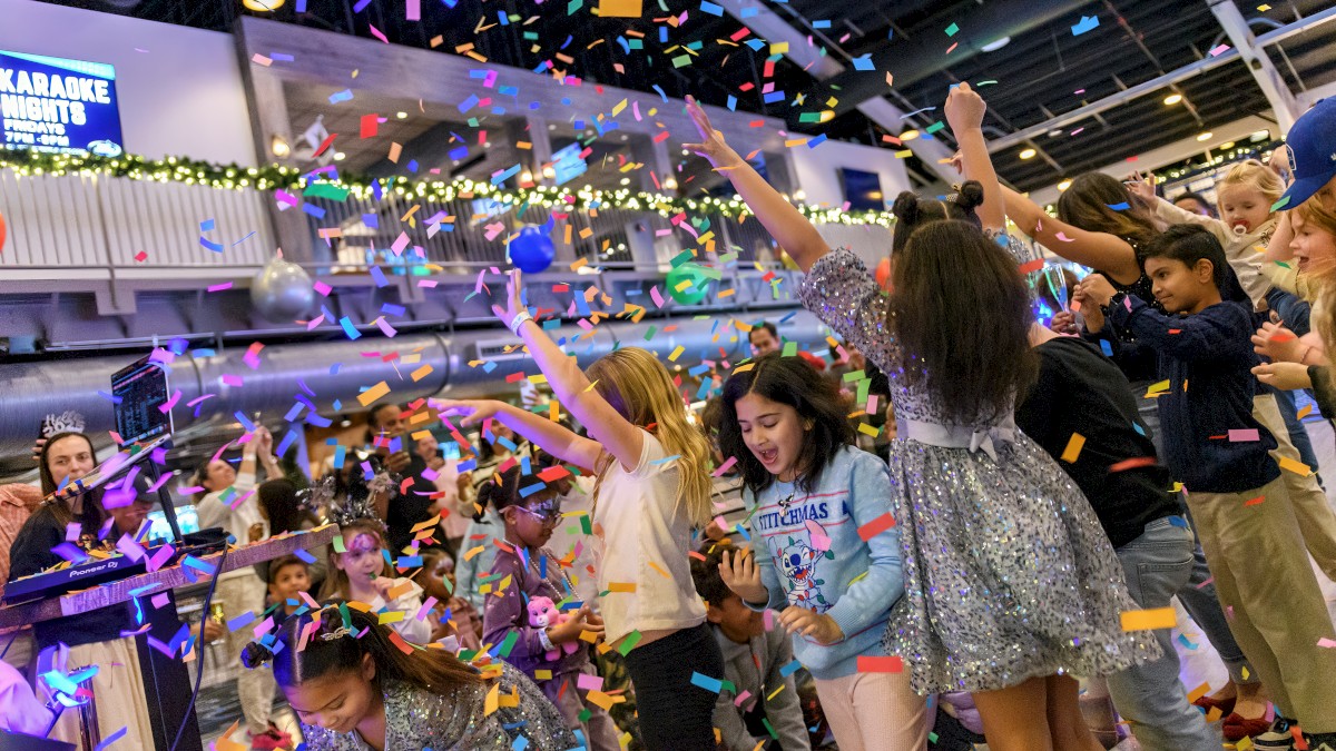 A lively party scene with children celebrating as colorful confetti rains down, creating a joyful atmosphere.