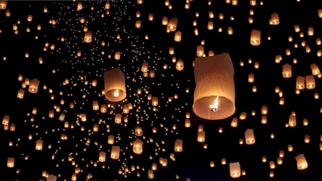 Floating lanterns illuminate the night sky, creating a stunning and magical scene.