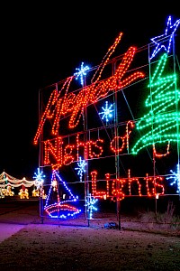 The image shows a festive light display with a sign reading 