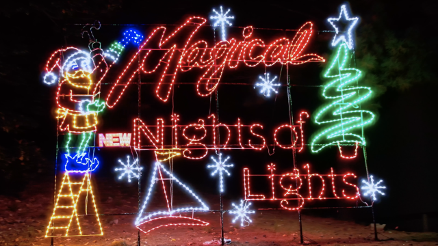 Colorful Christmas lights display with a festive message, Santa, a Christmas tree, snowflakes, and a sailboat, celebrating the holiday season.
