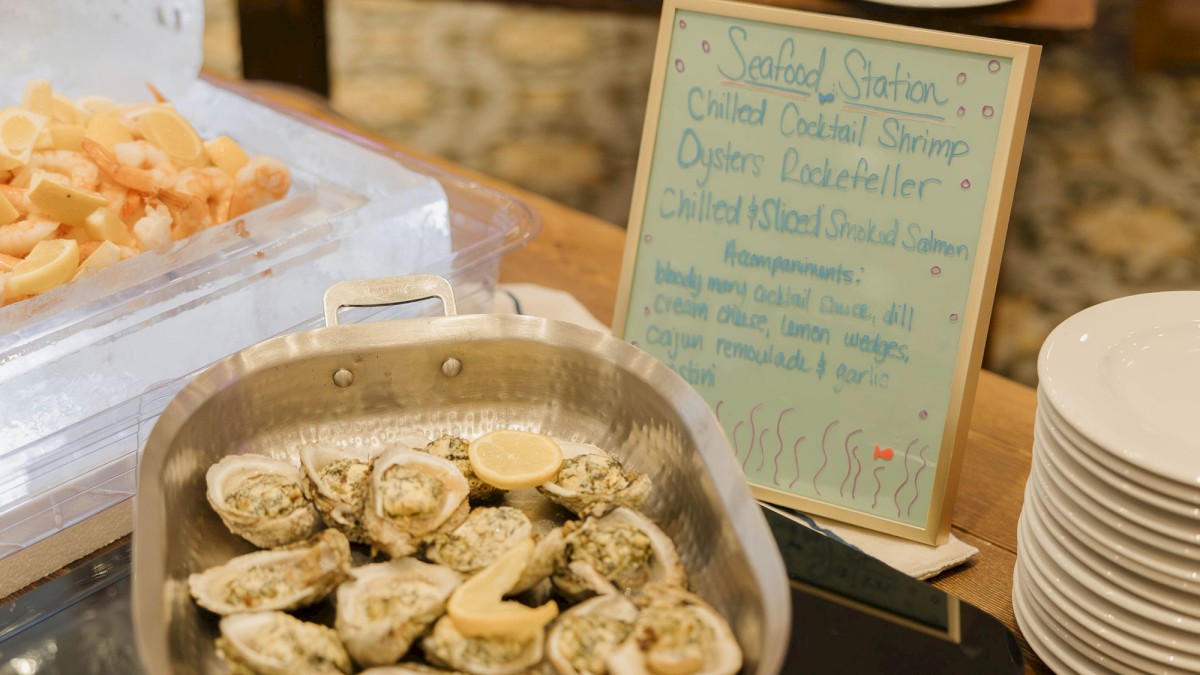A buffet spread with deviled eggs in a skillet, a blue sign, plates, and trays of appetizers in a restaurant setting.