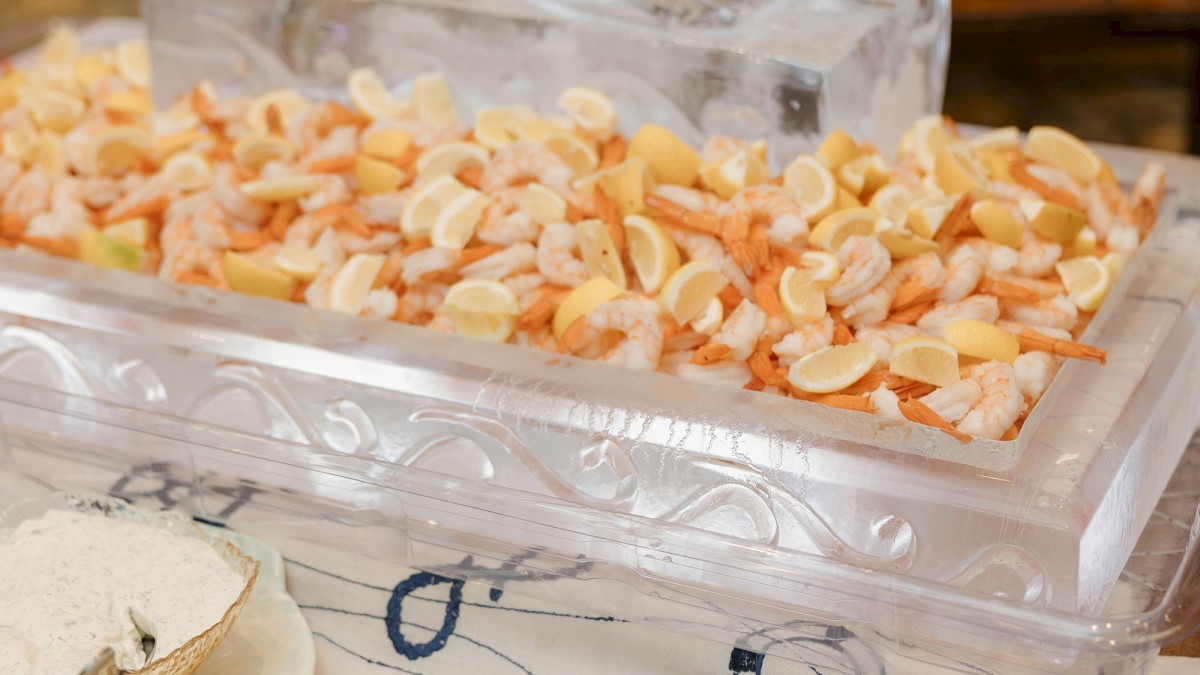 A display of peach-colored candy chunks arranged on a crystal platform, with a fork and small plates nearby on a wooden table.
