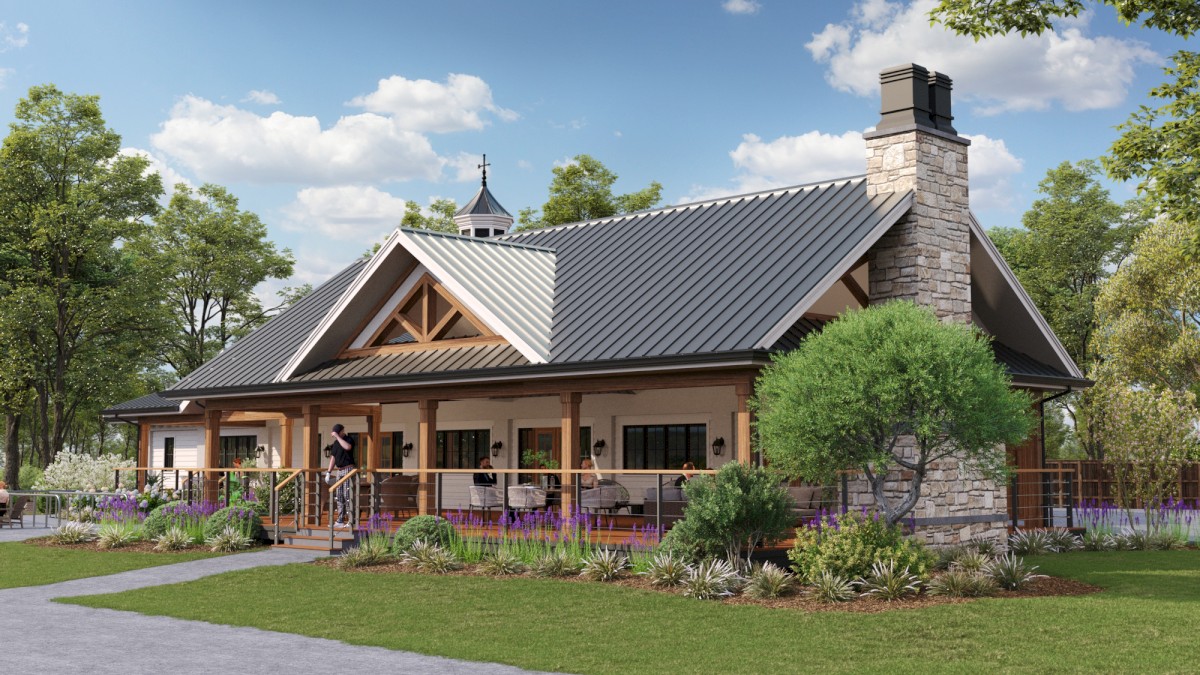 A cozy, wood-and-stone cottage with a metal roof, covered porch, lush greenery, and a well-kept lawn under a sunny sky.