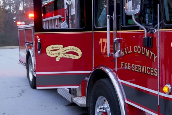 A red fire truck from Hall County Fire Services, showing slogans about honor, courage, commitment, and integrity.