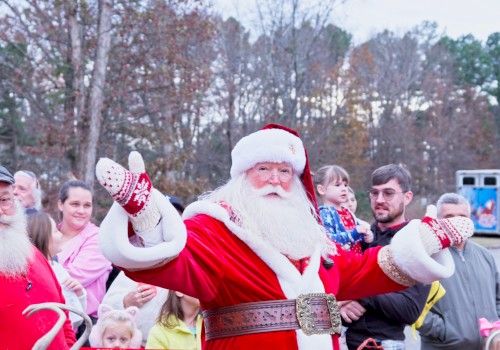 A cheerful Santa waves to a crowd in a park, with kids and adults gathered, festive outfits and a cozy holiday vibe. Ending this sentence.