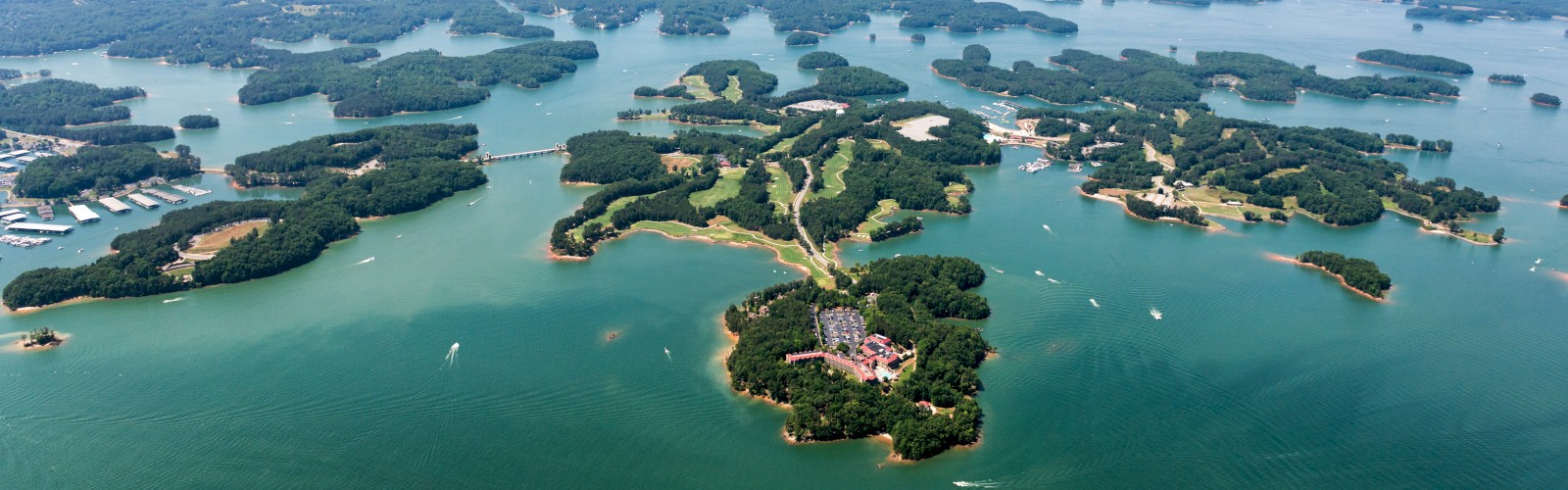 Aerial view of scenic islands and water bodies, with lush greenery and scattered buildings, possibly an archipelago or lake with many small islands.