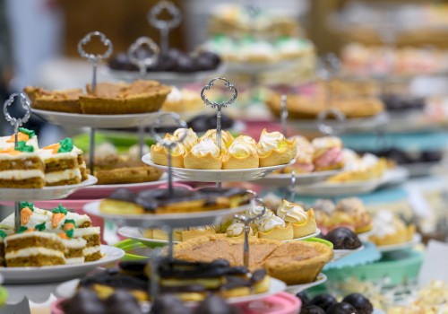 An array of desserts on tiered stands, including pies, cupcakes, and pastries, displayed in a colorful and inviting presentation.