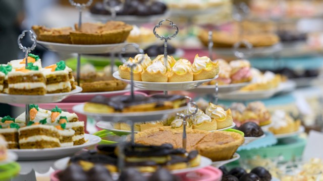 An array of desserts on tiered stands, including pies, cupcakes, and pastries, displayed in a colorful and inviting presentation.